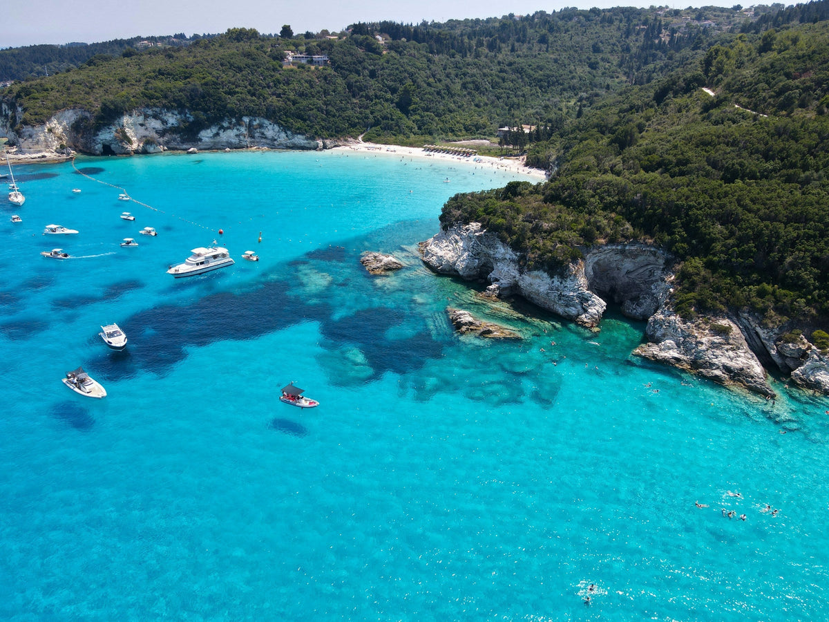 Yachts on luminous turquoise water off Antipaxos, Greece